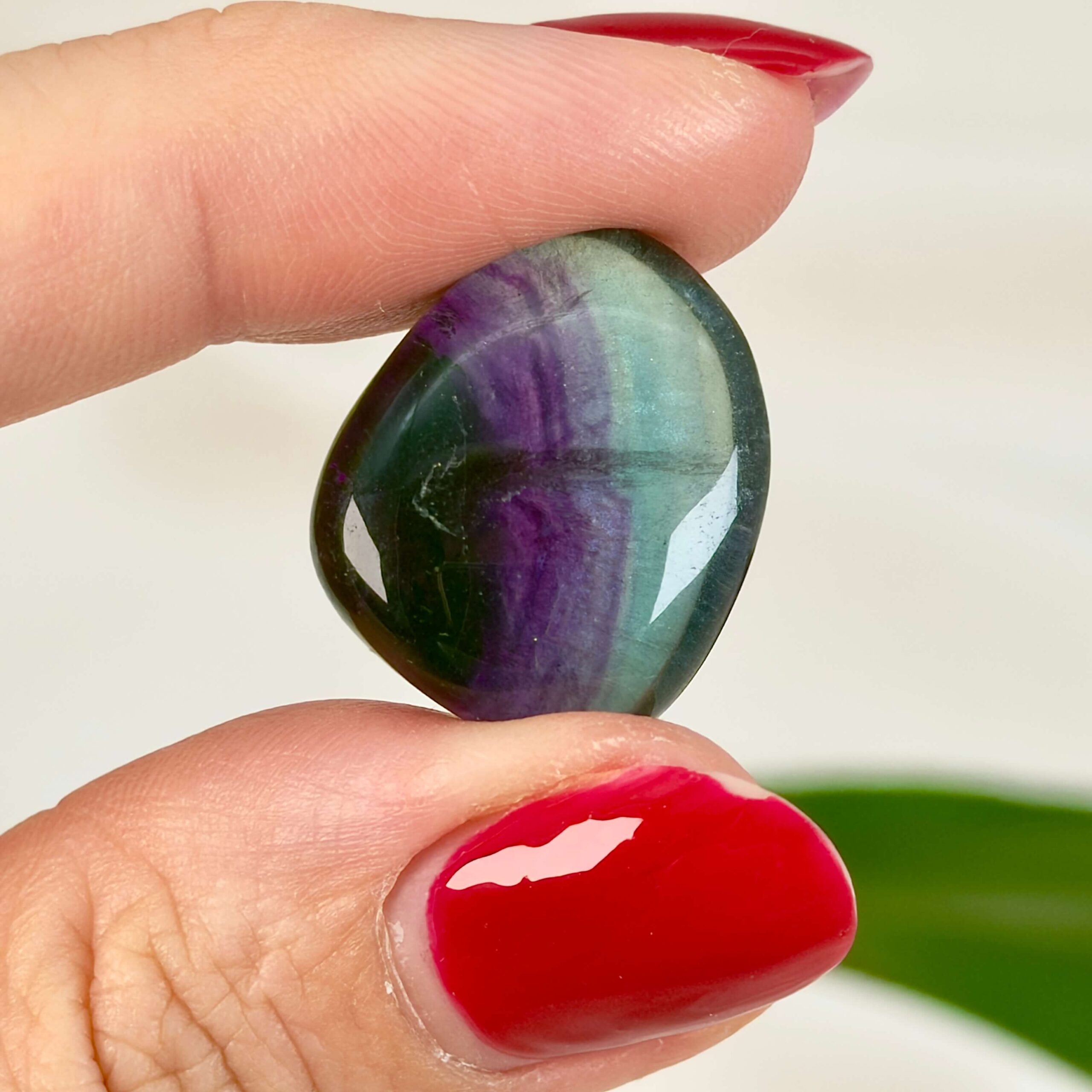 Fluorit Regnbue Lommesten Krystal Sten i hånd på hvid baggrund