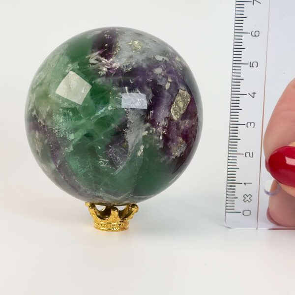 Fluorit regnbue krystal sten kugle ved siden af lineal med hvid baggrund
