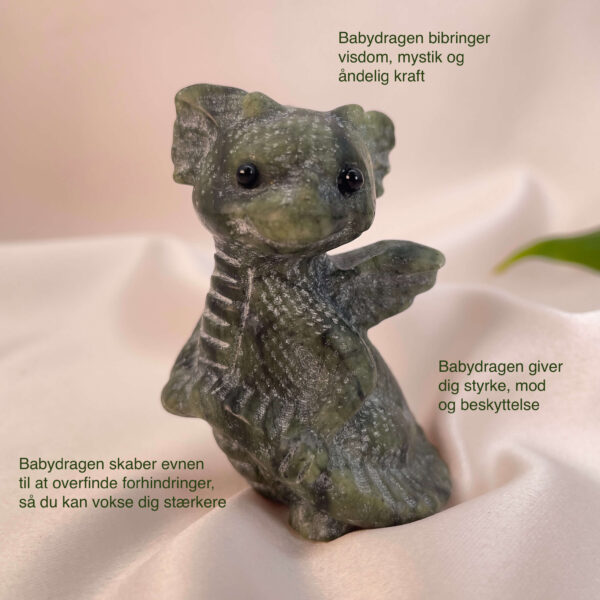 Serpentin krystal babydrage på hvid baggrund med grønt blad og tags