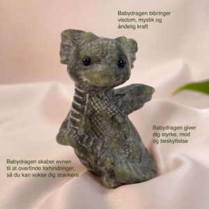 Serpentin krystal babydrage på hvid baggrund med grønt blad og tags