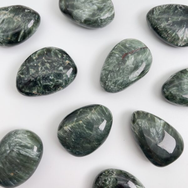 Serafinit håndpoleret krystal lommesten på hvid baggrund