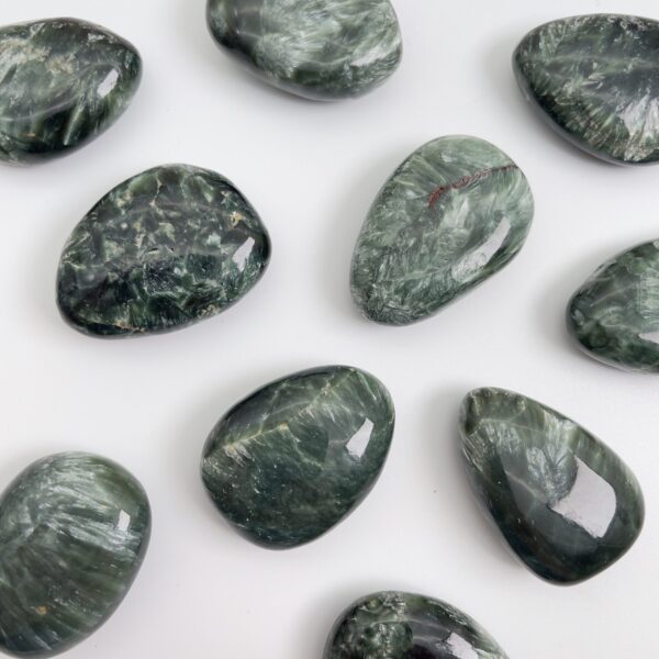 Serafinit håndpoleret krystal lommesten på hvid baggrund