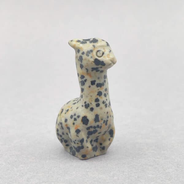 Fin lille alpaca i sten – symbol på ro og venlighed.