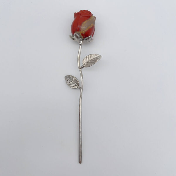 Kraftfuld rød krystalrose på sølvstilk med varm og jordnær energi.