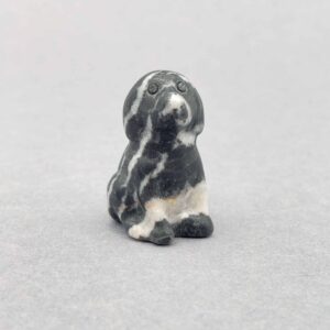 Poleret hundefigur med glansfuld overflade og rolig energi.