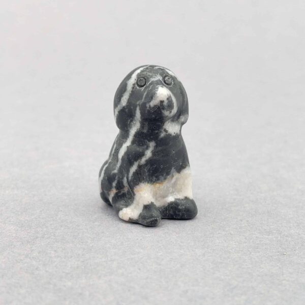 Poleret hundefigur med glansfuld overflade og rolig energi.