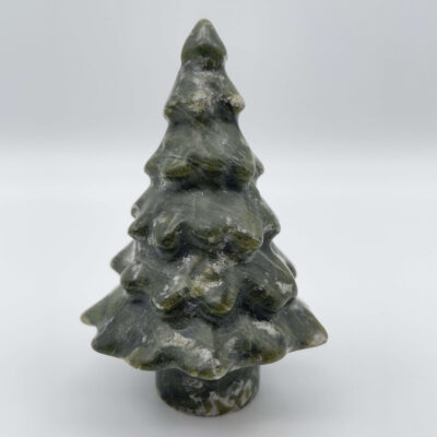 Poleret serpentin juletræ med harmoniske farver og blid glød.