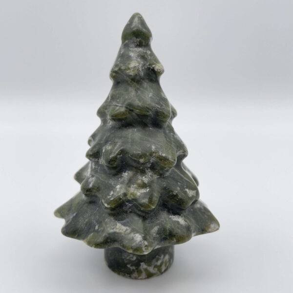 Poleret serpentin juletræ med harmoniske farver og blid glød.