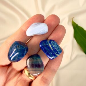 Kommunikation krystal healingssæt liggende på hånd med hvid baggrund med grønt blad