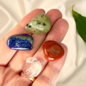 Svimmelhed krystal healingssæt liggende på hånd med hvid baggrund med grønt blad