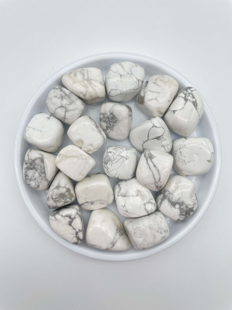 Howlit krystaller i hvidt fad på hvid baggrund