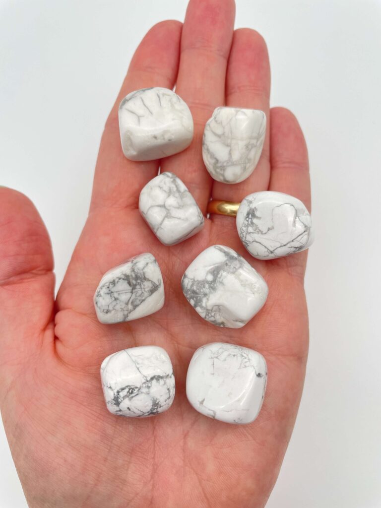 Howlit krystaller i hånd med hvid baggrund