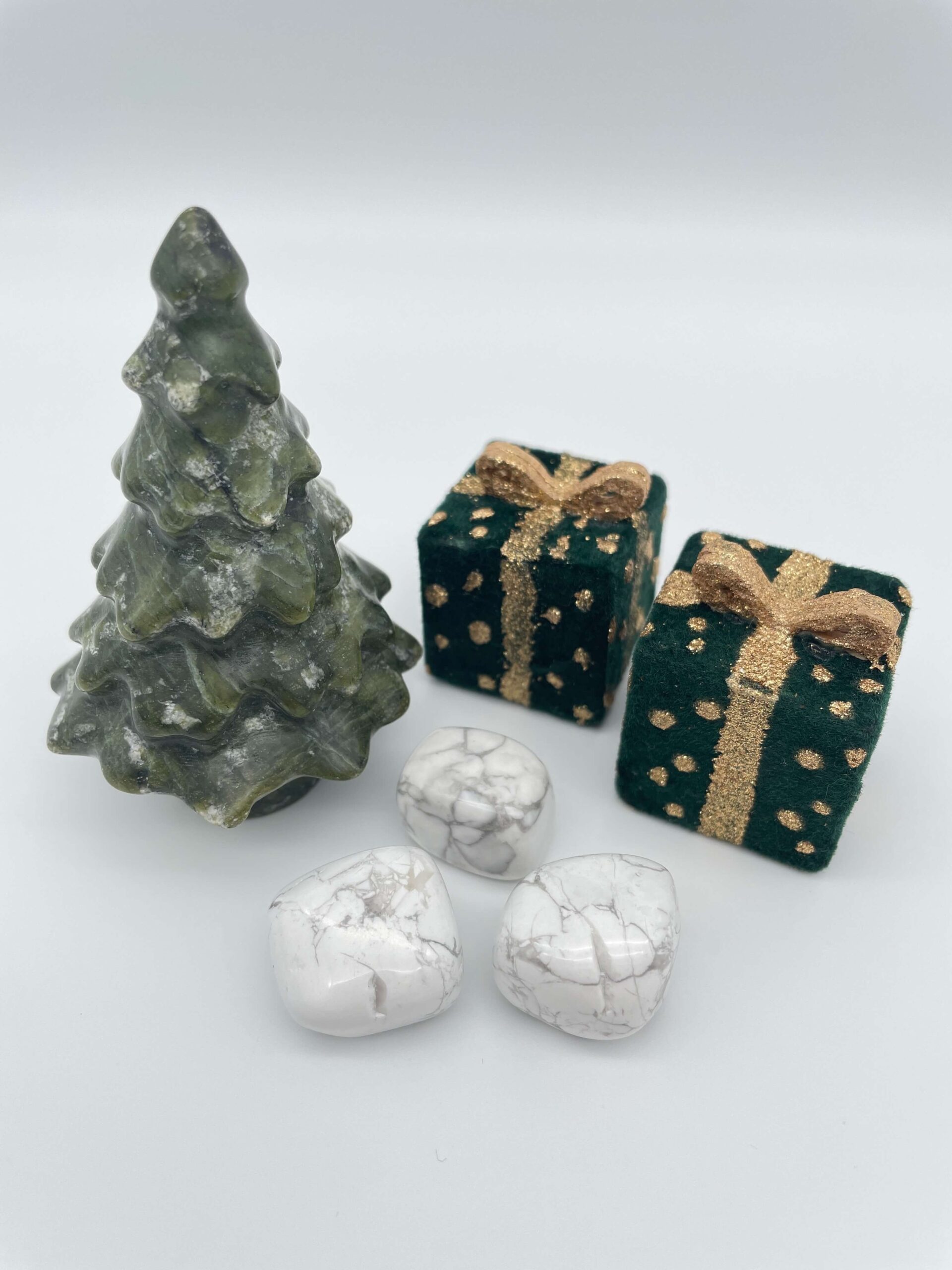 Howlit krystaller ved siden af juletræ og pakker på hvid baggrund