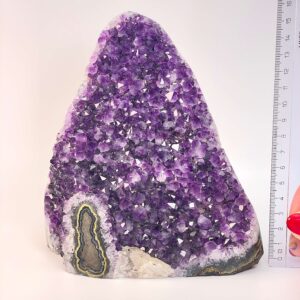 Ametyst krystal rå grotte klynge sten ved siden af lineal på hvid baggrund