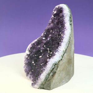 Ametyst krystal rå grotte klynge sten på hvid plade med lilla baggrund fra siden