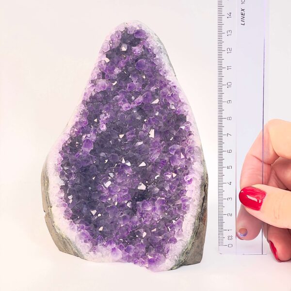 Ametyst krystal rå grotte klynge sten ved siden af lineal på hvid baggrund