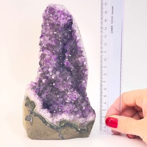 Ametyst krystal rå grotte klynge sten ved siden af lineal på hvid baggrund