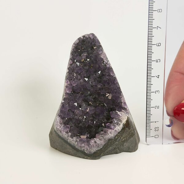 Ametyst krystal rå grotte klynge sten ved siden af lineal på hvid baggrund