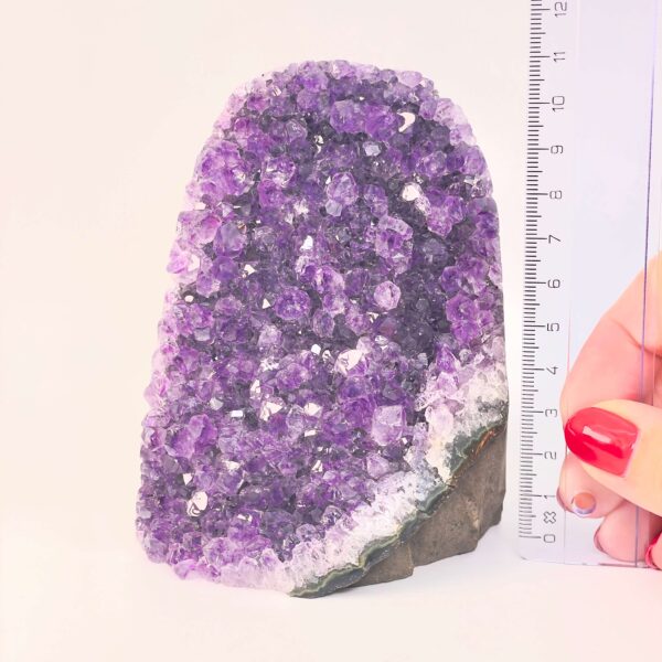 Ametyst krystal rå grotte klynge sten ved siden af lineal på hvid baggrund