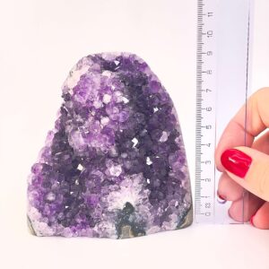 Ametyst krystal rå grotte klynge sten ved siden af lineal på hvid baggrund