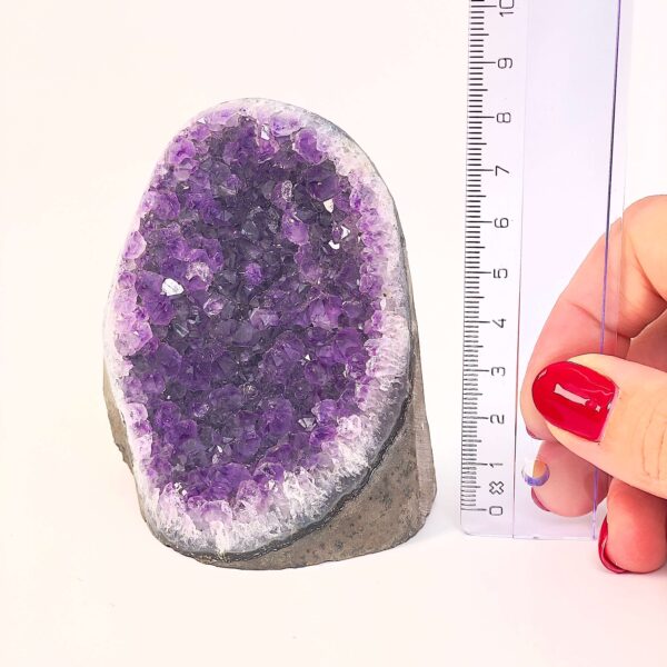 Ametyst krystal rå grotte klynge sten ved siden af lineal på hvid baggrund