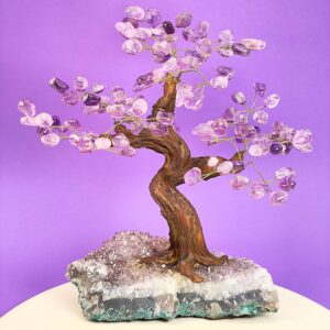 Ametyst træ på krystal bund på hvid plade med lilla baggrund