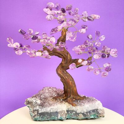 Ametyst træ på krystal bund på hvid plade med lilla baggrund