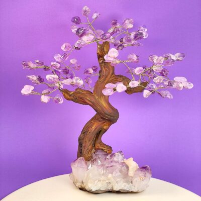 Ametyst træ på krystal bund på hvid plade med lilla baggrund