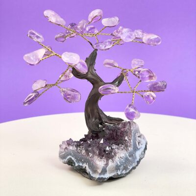 Ametyst træ på krystal bund på hvid plade med lilla baggrund