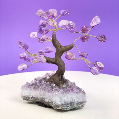 Ametyst træ på krystal bund på hvid plade med lilla baggrund