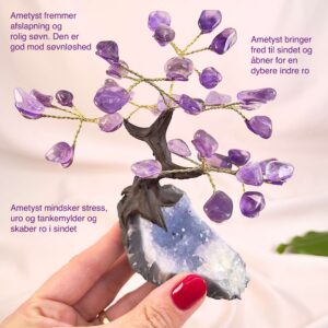 Ametyst træ på krystal bund i hånd med lys baggrund og grønt blad