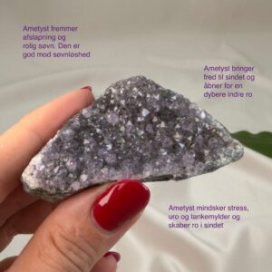 Ametyst krystal rå klynge sten i hånd med hvid baggrund og grønt blad med tags