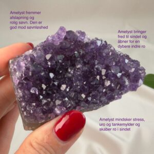 Ametyst krystal rå klynge sten i hånd med hvid baggrund og grønt blad med tags