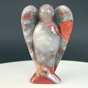 Blodsten krystal engel på hvid plade med sort baggrund