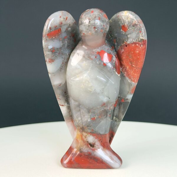 Blodsten krystal engel på hvid plade med sort baggrund