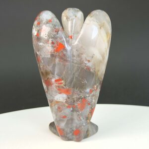 Blodsten krystal engel bagfra på hvid plade med sort baggrund