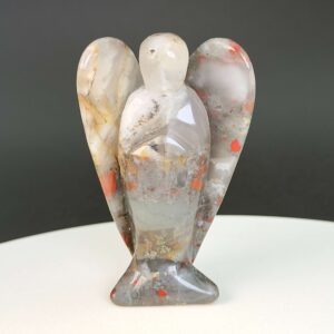 Blodsten krystal engel på hvid plade med sort baggrund