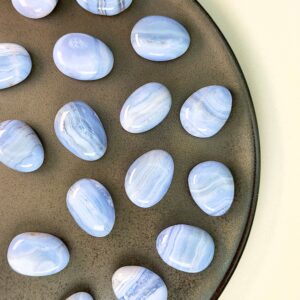 Blondeagat håndpoleret krystal lommesten på brunt fad med hvid baggrund