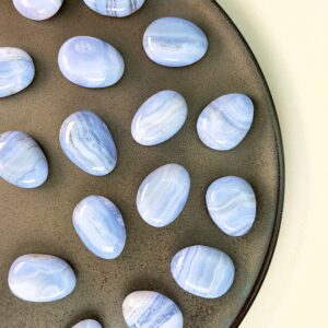 Blondeagat håndpoleret krystal lommesten på brunt fad med hvid baggrund