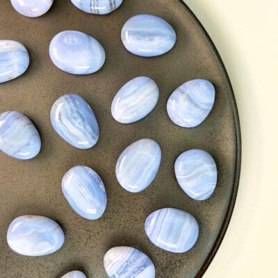 Blondeagat håndpoleret krystal lommesten på brunt fad med hvid baggrund