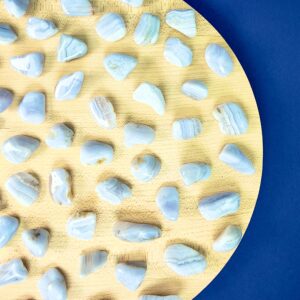 Blondeagat krystal lommesten på træfad med blå baggrund