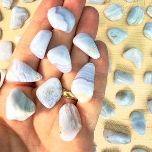 Blondeagat krystal lommesten på hand med blondeagater på træfad i baggrunden