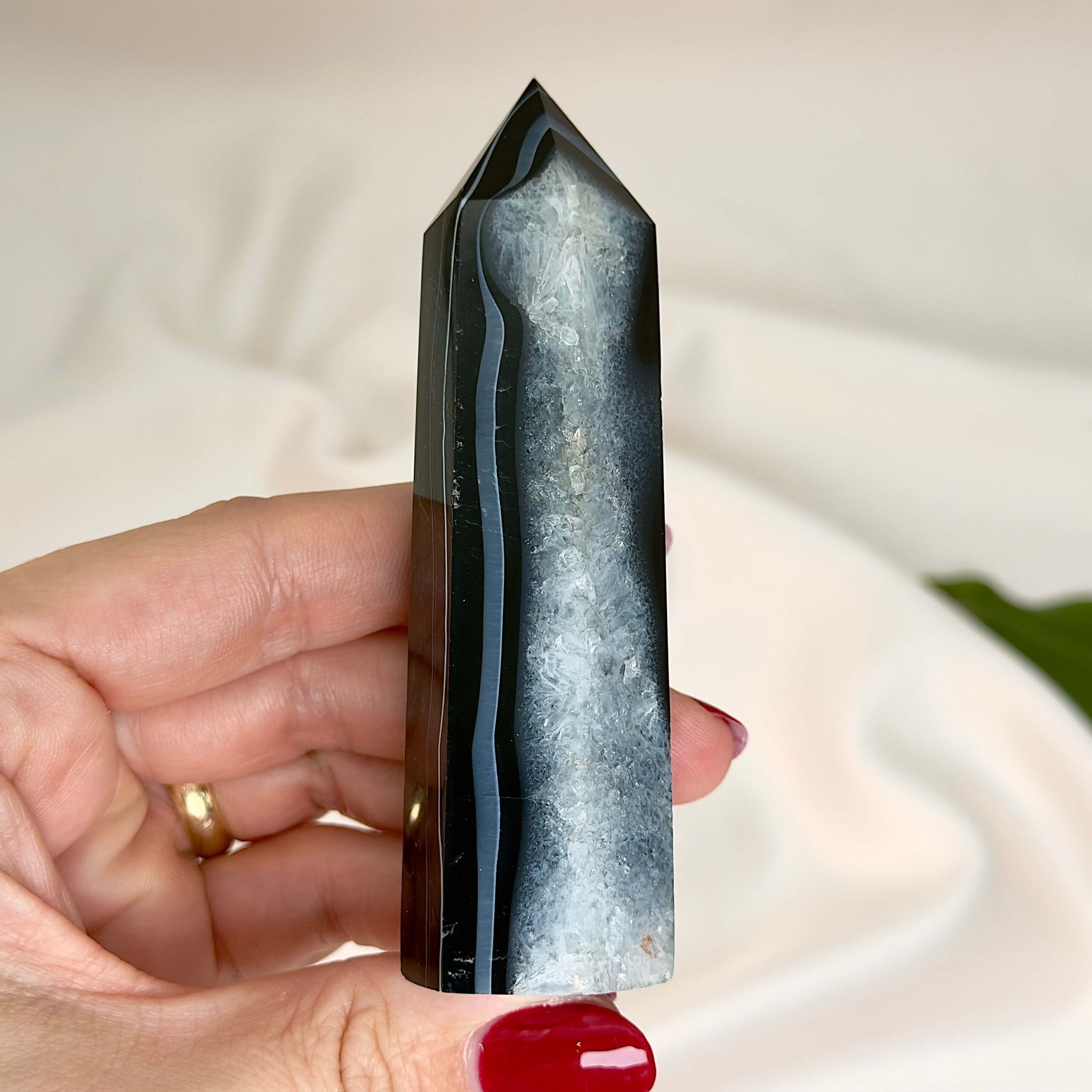 Agat sort krystal tårn sten på hvid baggrund i hånd