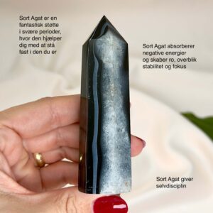 Agat sort krystal tårn sten på hvid baggrund i hånd med tags