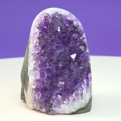 Ametyst krystal rå grotte klynge sten med hvid og lilla baggrund