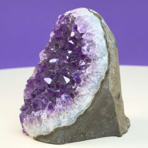 Ametyst krystal rå grotte klynge sten med hvid og lilla baggrund