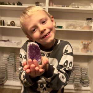 Ametyst krystal rå grotte klynge sten i hånd på dreng Elias