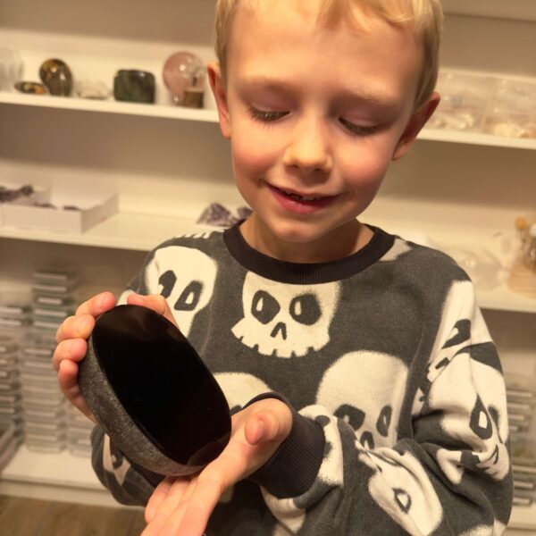 Sort Obsidian Flodsten Freeform krystal sten i hånd på dreng Elias