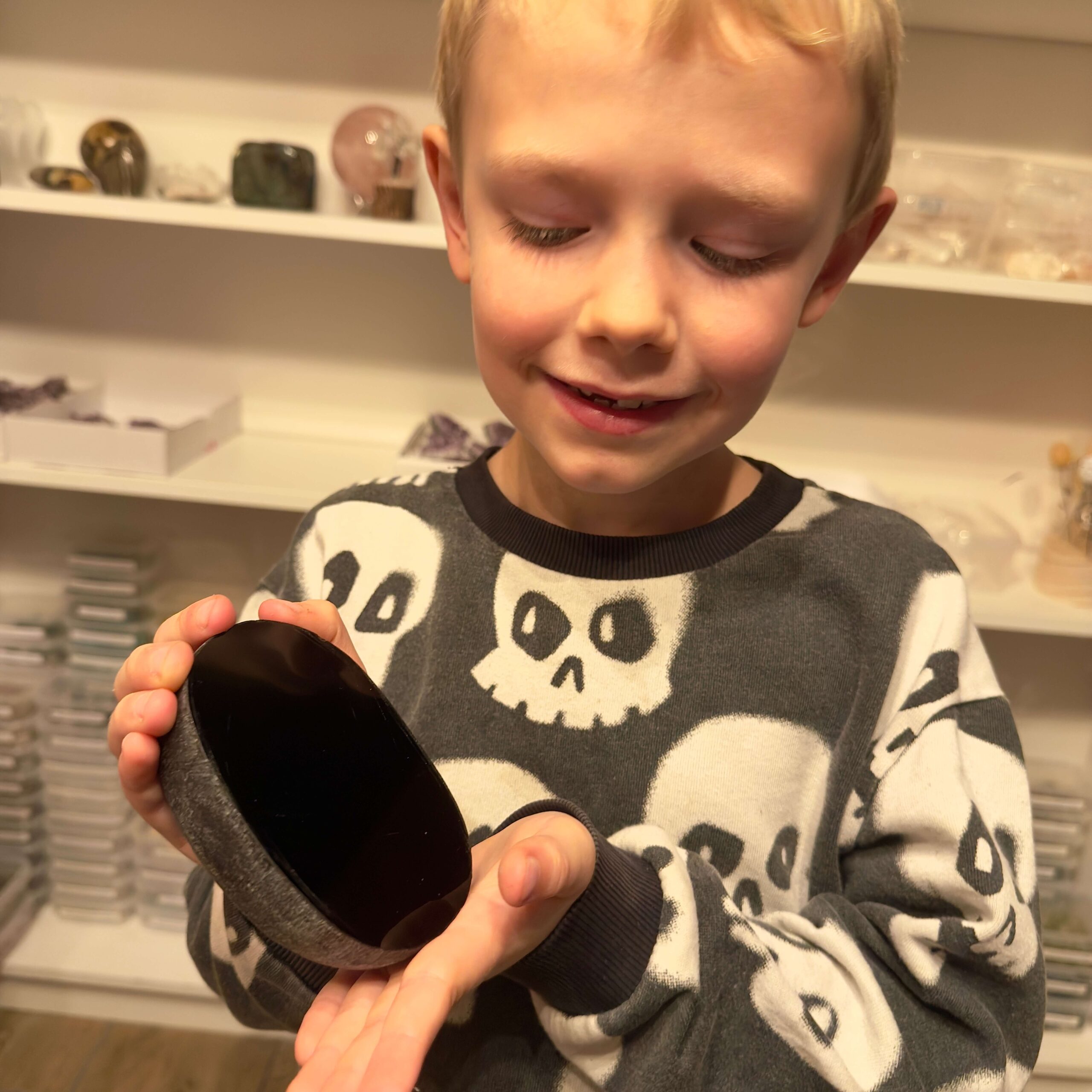 Sort Obsidian Flodsten Freeform krystal sten i hånd på dreng Elias