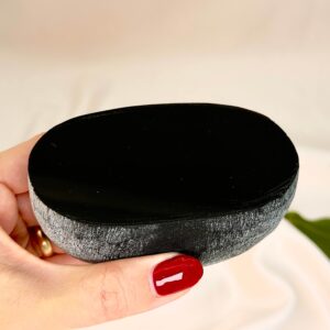 Sort Obsidian Flodsten Freeform krystal sten i hånd på hvid baggrund